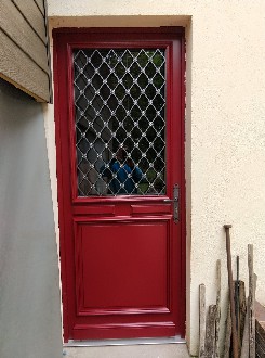 Pose d'une porte en bois peinte en rouge