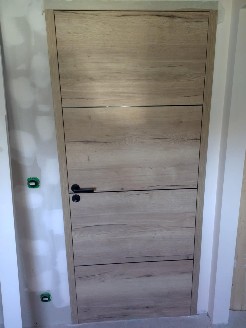 Pose d'une porte intérieure en aspect bois avec huisserie fin de chantier