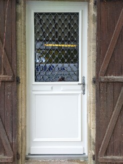 Pose d'une porte d'entrée en Moabi prélaqué blanc cassé