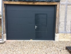 Pose d'une porte de garage sectionnelle motorisée gris anthracite avec un portillon