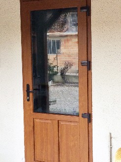 Pose d'une porte de service en Pvc imitation bois avec ouverture extérieure        