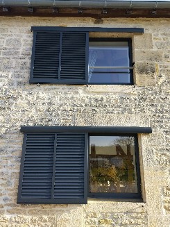 Pose de volets coulissants en aluminium gris anthracite.